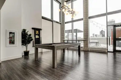 a pool table in a room with large windows at Stylish Downtown Suite with Patio & City Views in Kitchener