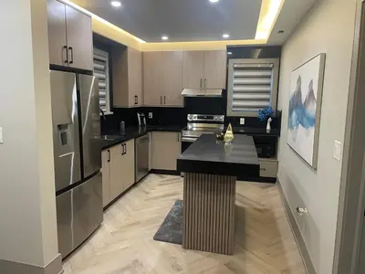 a kitchen with a black counter and a refrigerator at Modern 4 Bedroom Ground Floor Bungalow Style Home in Niagara Falls