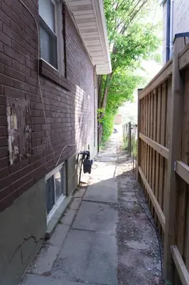 an alley between a brick building and a fence at Modern 3 Bedroom Guest Suite in Toronto