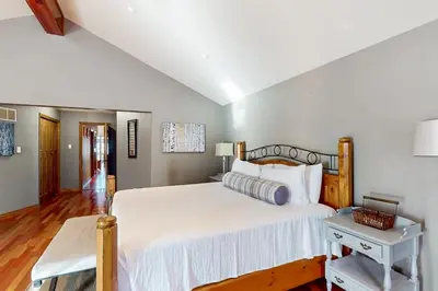 a bedroom with a large white bed and a table at Main House in Wasaga Beach