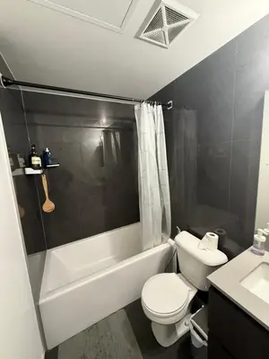 a bathroom with a toilet and a tub and a sink at Condo in the heart of toronto in Toronto