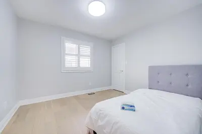 a white bedroom with a bed and a window at Vantage stay Stouffville 4BR Bright Home in Stouffville