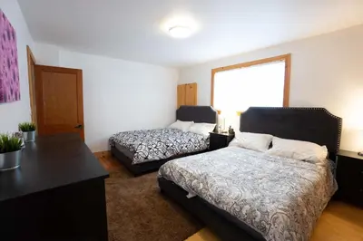 a bedroom with two beds and a desk at Cottage on Crystal Beach 3BR & BBQ in Fort Erie