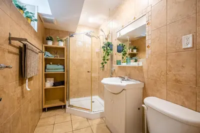 a bathroom with a shower and a toilet and a sink at Basement Suite for 2 w Private Patio in Toronto in Toronto