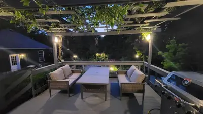 an outdoor patio with a table and chairs at night at Charlotte Garden Bed and Breakfast in Niagara on the Lake