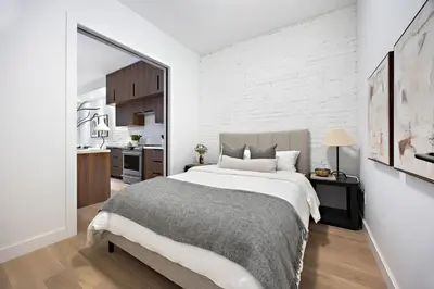 a bedroom with a large bed and a white brick wall at The Brick Hotel - The Second Suite in Toronto