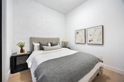 a bedroom with a large bed with white walls at The Brick Hotel - The Second Suite in Toronto