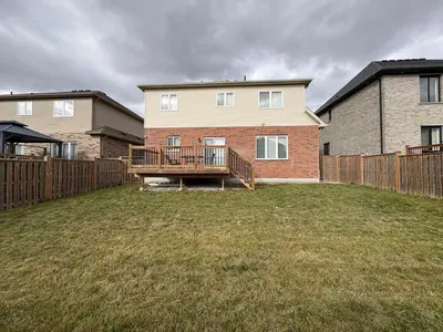 a large yard with a house and a wooden deck at Entire home in London, Ontario, Canada in London