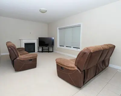 a living room with two chairs and a television at Entire home in London, Ontario, Canada in London