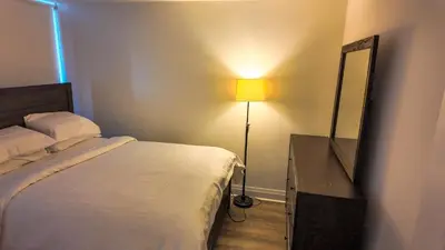 a bedroom with a bed and a mirror and a lamp at 17 Zorra street in Toronto