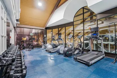 a gym with treadmills and ellipticals in a building at Luxury Jacuzzi Suite with Sauna & Heated Pool in Shanty Bay