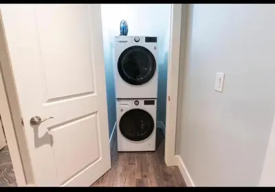 a washer and dryer sitting next to a door at Modern Cozy Executive Suite with Private Entrance in London