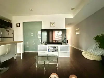 a living room with a glass table and a kitchen at Luxury smart condo downtown Toronto in Toronto