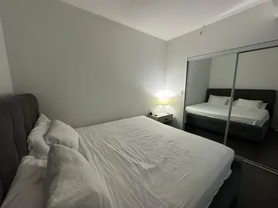 a bedroom with a mirror and two beds in it at Luxury smart condo downtown Toronto in Toronto