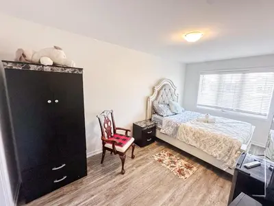a bedroom with a bed and a dresser and a chair at Quiet Haven in Oshawa