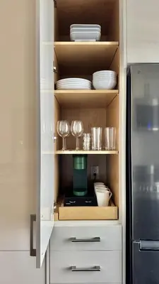 a cupboard filled with plates and glasses and a refrigerator at Bright & Cozy Private Studio Apartment in Toronto