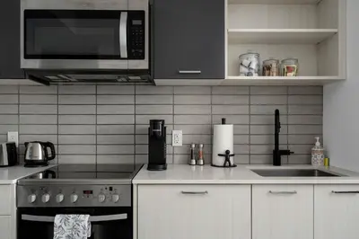 a kitchen with a stove and a microwave at Modern 2 Bed Condo in the Junction+Parking in Toronto