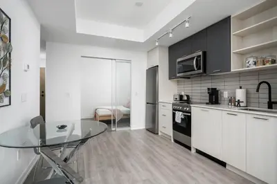 a kitchen with a table and a counter top at Modern 2 Bed Condo in the Junction+Parking in Toronto