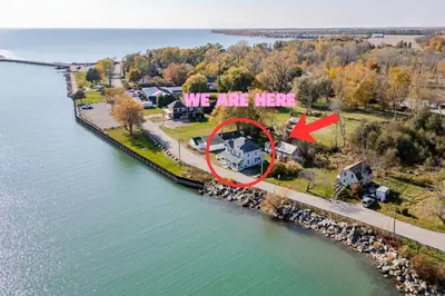 an aerial view of a house with a sign that says we are here at Waterfront Cottage, Top Fishing Spot, Light House