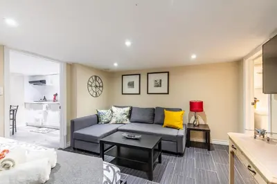 a living room with a couch and a table at Cozy Suite Condo - Heart Of St Clair West - Bloor Hotel in Toronto