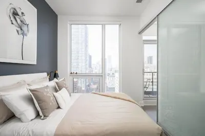 a bedroom with a bed and a large window at Style & Comfort in the Heart of Toronto in Toronto