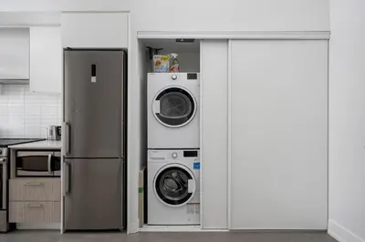 a kitchen with a refrigerator and two washing machines at Style & Comfort in the Heart of Toronto in Toronto