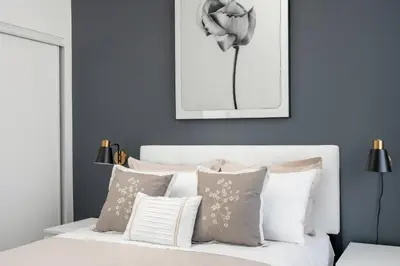 a bedroom with blue walls and a white bed with pillows at Style & Comfort in the Heart of Toronto in Toronto