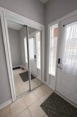 a mirror in a room with a hallway with windows at Private & Spacious King-size Bedroom with 3 Bath access! Brampton Shared Home with Full Kitchen, WiFi, Laundry & Backyard Deck! Near Mount Pleasant GO, Ideal for Work Trips, Long Stays & Solo Travelers! in Brampton