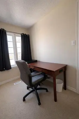 an office with a desk and a chair and a window at Private & Spacious King-size Bedroom with 3 Bath access! Brampton Shared Home with Full Kitchen, WiFi, Laundry & Backyard Deck! Near Mount Pleasant GO, Ideal for Work Trips, Long Stays & Solo Travelers! in Brampton