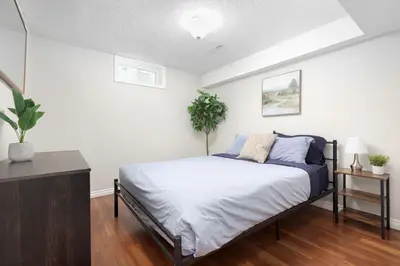 a bedroom with a bed with blue pillows at Roomy 1BD Apartment in Basement of House in Mississauga