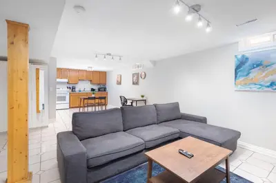 a living room with a gray couch and a table at Roomy 1BD Apartment in Basement of House in Mississauga