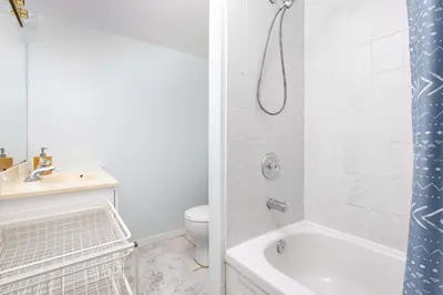 a bathroom with a tub and a toilet and a sink at Roomy 1BD Apartment in Basement of House in Mississauga