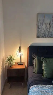 a bedroom with a bed and a table with a lamp at apartment for 2 by water in St. Catharines
