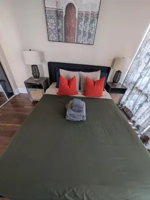 a bedroom with a large bed with red pillows at Nice Place Central to Downtown in St. Catharines