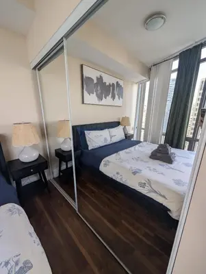 a bedroom with two beds and a large mirror at Nice Place Central to Downtown in St. Catharines