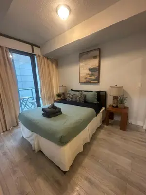 a bedroom with a bed and a large window at Functional Condo Sleep 6 in Port Hope