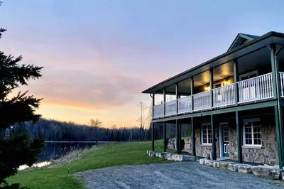 a house on a hill with a sunset in the background at Cajun Cabin Private Nature Resort in Minden