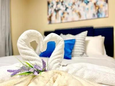 a white towel wrapped around a flower on a bed at Paris Charm Modern 4B3B, Kitchen, Parking,5G in Richmond Hill