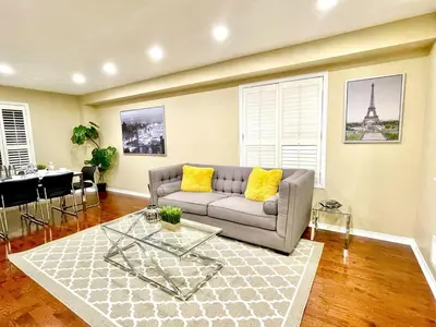 a living room with a couch and a table at Paris Charm Modern 4B3B, Kitchen, Parking,5G in Richmond Hill