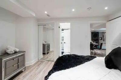 a white bedroom with a large bed and a mirror at Luxury 2 Bedroom 2Bathroom Modern B Apartment in Ajax, Toronto in Ajax
