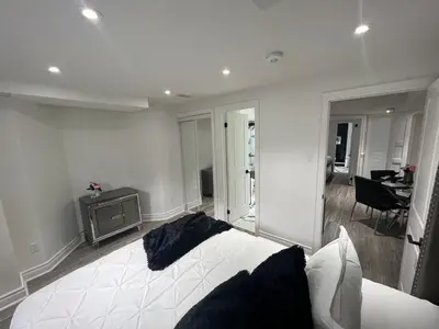 a bedroom with a white bed and a living room at Luxury 2 Bedroom 2Bathroom Modern B Apartment in Ajax, Toronto in Ajax