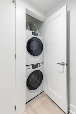 a laundry room with a washer and dryer at Westend Suites - Bright & Inviting 3BR Hotel near High Park in Toronto