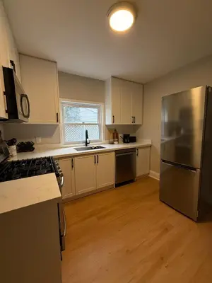 a kitchen with white cabinets and a stainless steel refrigerator at The Maple and Mist in Niagara Falls