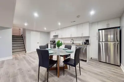 a kitchen with a table and chairs and a refrigerator at 10 Acre Farmhouse with Pool + 5 Bedrooms/3 Baths in East Gwillimbury