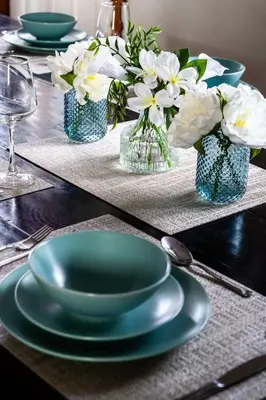 a table with a green plate and vases of flowers at Large chalet 3 King bed Sauna-Hot Tubs Projector in Blue Mountains