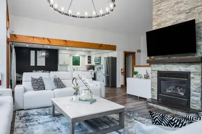 a living room with a white couch and a fireplace at Large chalet 3 King bed Sauna-Hot Tubs Projector in Blue Mountains