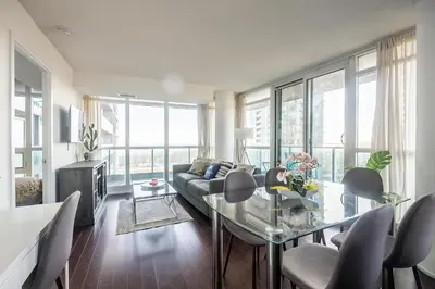 a living room with a couch and a glass table at Panoramic 2 Bedroom Condo with Terrace Fort York Downtown Toronto in Toronto