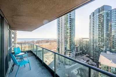 a balcony with two chairs and a table at Panoramic 2 Bedroom Condo with Terrace Fort York Downtown Toronto in Toronto