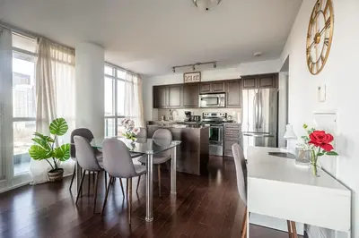 a kitchen and dining room with a table and chairs at Panoramic 2 Bedroom Condo with Terrace Fort York Downtown Toronto in Toronto