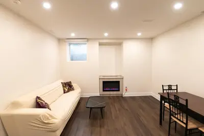 a living room with a white couch and a fireplace at New Basement Apartment with parking in Oakville